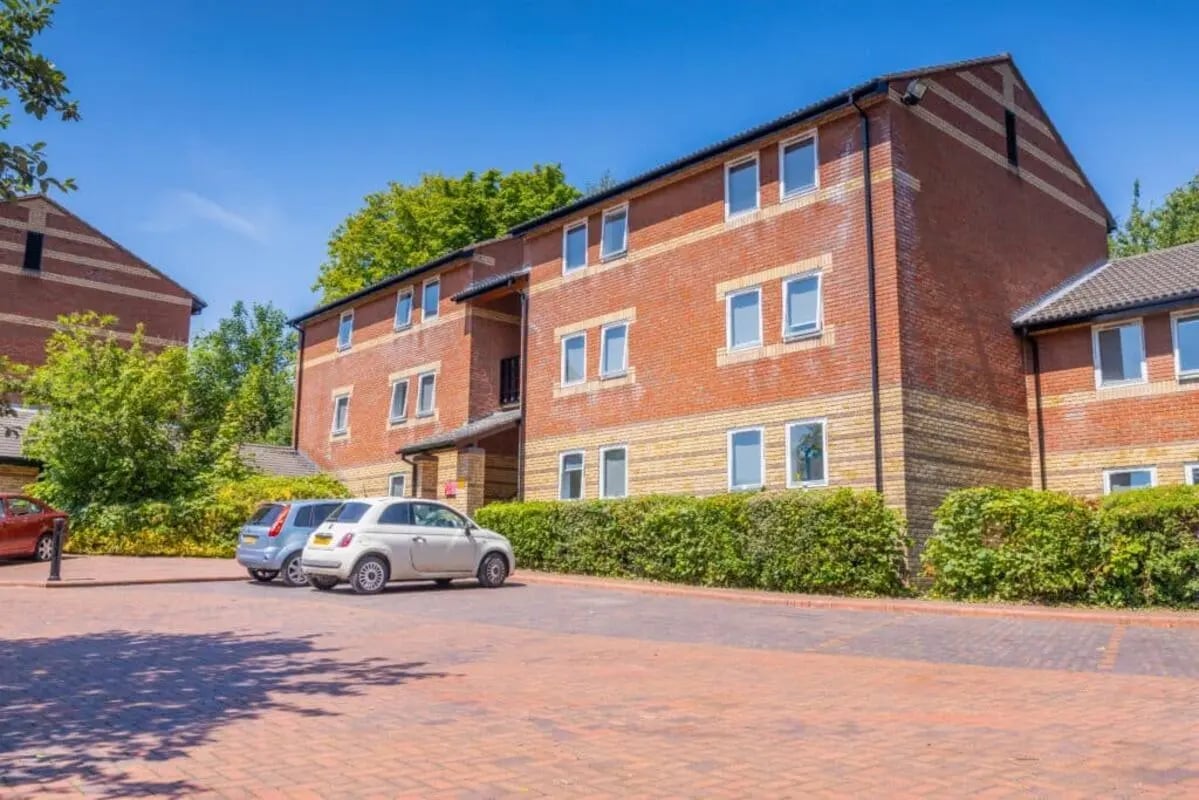 Brick building with cars and parking lot exterior at Beech Gardens in Birmingham Student Accommodation