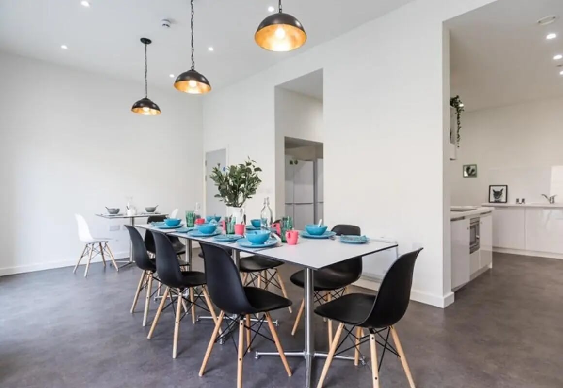 Dining table set for meals with chairs kitchen living room at The Cam Foundry in Cambridge Student Accommodation