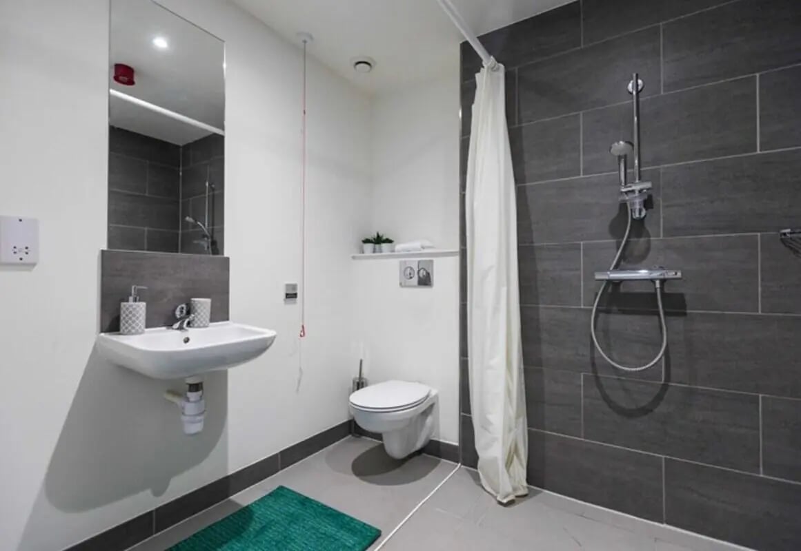 Sink toilet shower with curtain bathroom at The Cam Foundry in Cambridge Student Accommodation