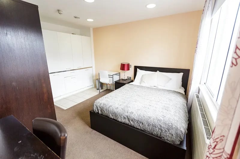 Bed desk white wardrobe cabinets bedroom at AXO Oxford Circus in London Student Accommodation