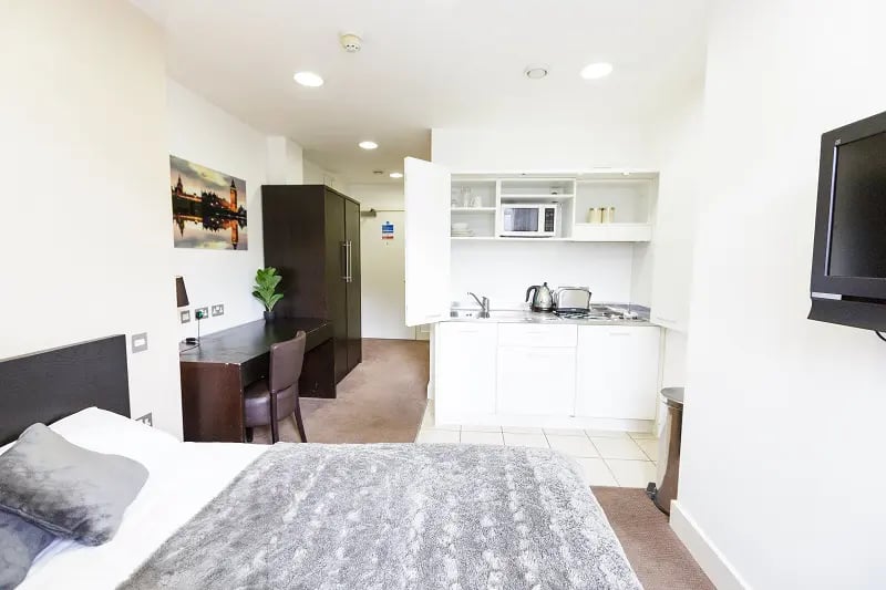 Bed desk wardrobe kitchen and television studio at AXO Oxford Circus in London Student Accommodation