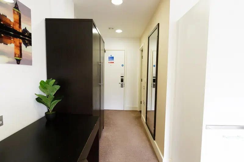 Wardrobe plant desk doors mirror hallway interior at AXO Oxford Circus in London Student Accommodation