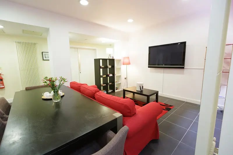 Dining table red sofa television living room at AXO Oxford Circus in London Student Accommodation