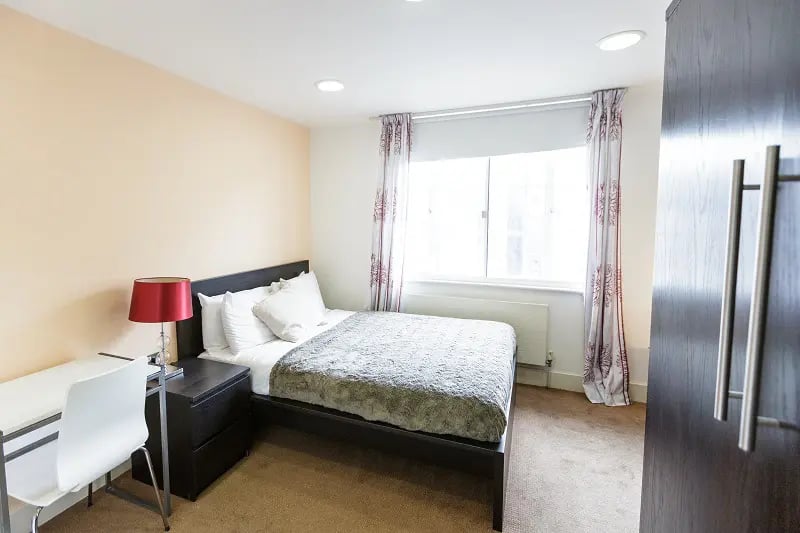 Bed desk lamp nightstand and closet bedroom at AXO Oxford Circus in London Student Accommodation