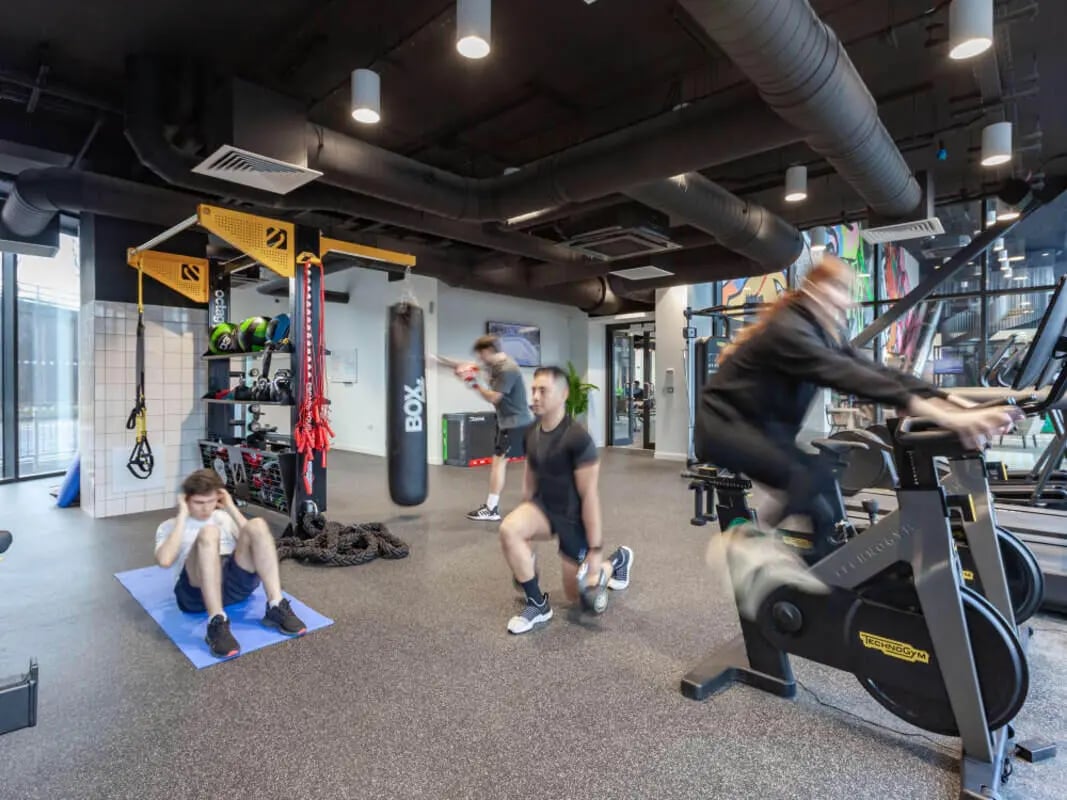 People exercising with weights boxing bag and bikes gym area at True Glasgow in Glasgow Student Accommodation