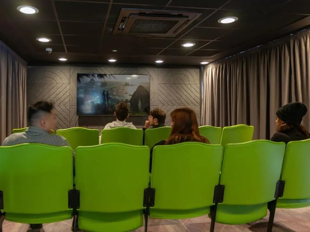 Green seats facing a screen in a cinema room at True Glasgow in Glasgow Student Accommodation