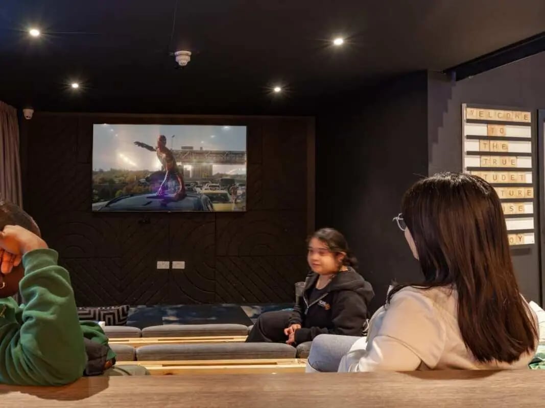 Screen TV and people watching movie lounge at True Birmingham in Birmingham Student Accommodation