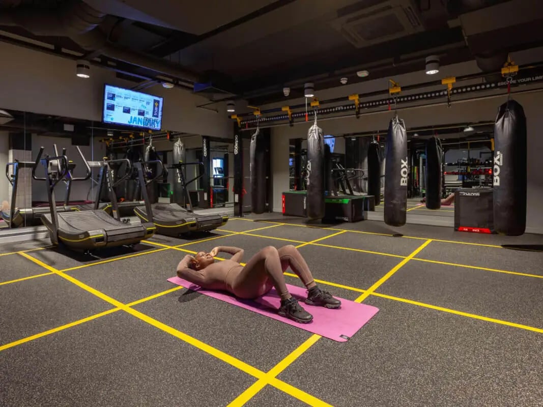 Gym with treadmills punchbags and woman exercising gym at True Birmingham in Birmingham Student Accommodation