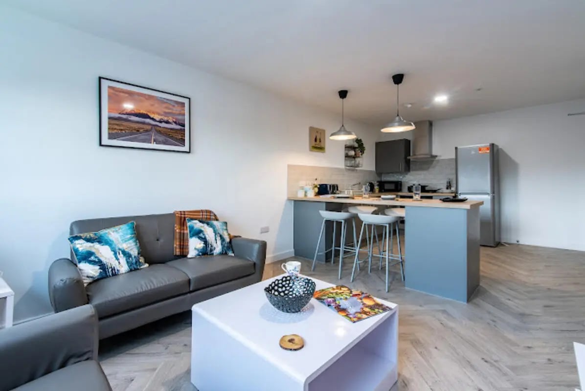 Sofa table kitchen with bar stools living room at Broadgate House Student Living in Nottingham Student Accommodation