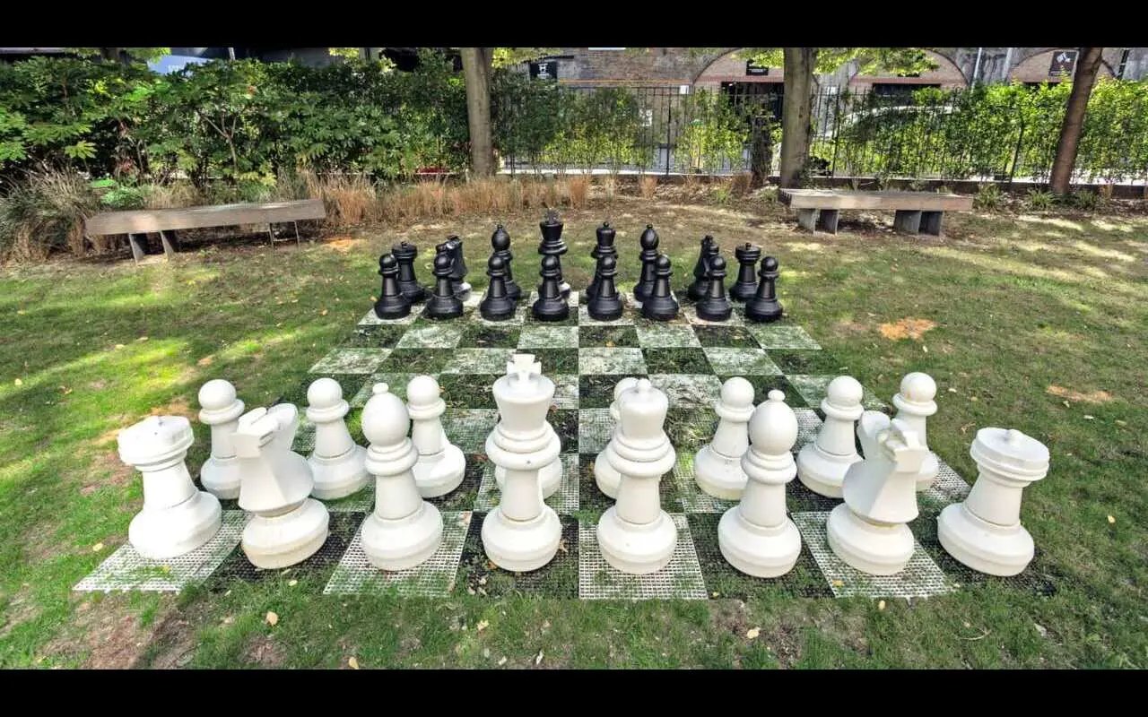 Giant chess pieces arranged on board outdoor area exterior at Griffon Studios in London Student Accommodation