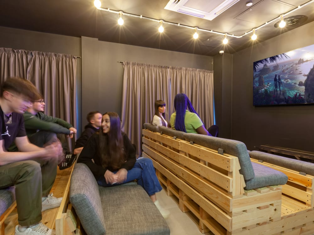 Students watching TV on pallet couches communal area at True Liverpool in Liverpool Student Accommodation