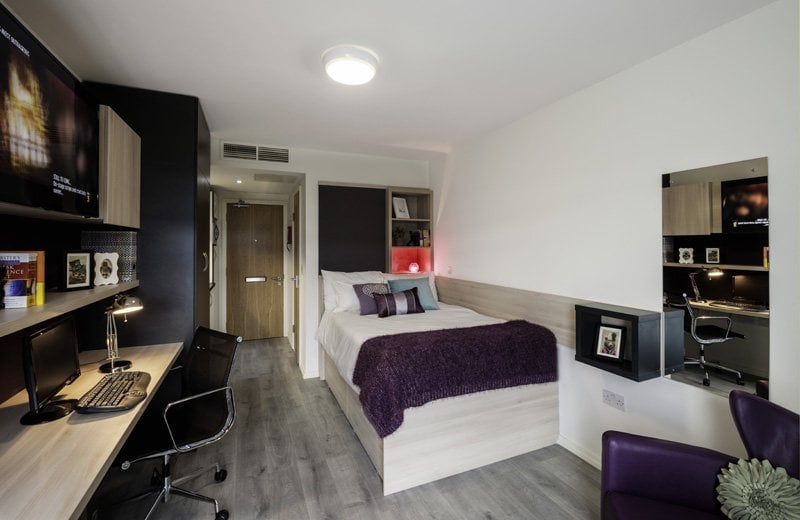 Bed desk TV and purple chair bedroom at The Lyra in London Student Accommodation