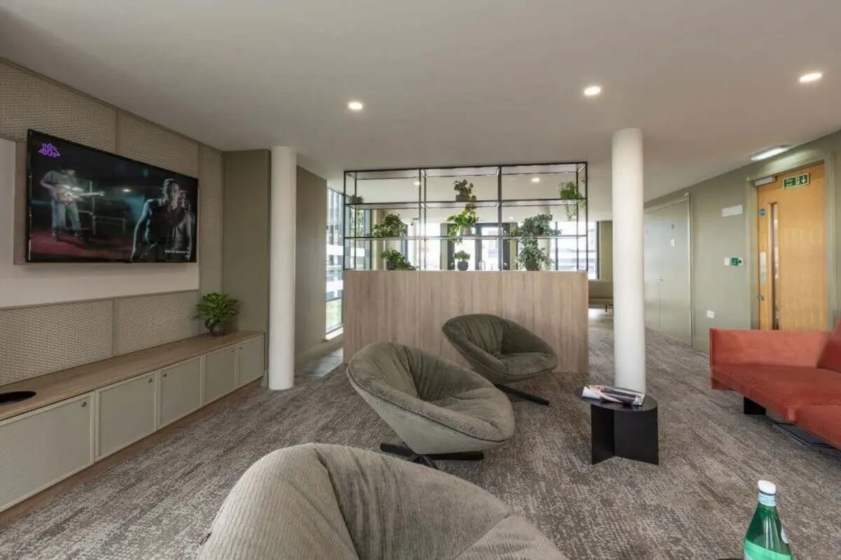 Sofa chairs TV and plants living room at The Lyra in London Student Accommodation