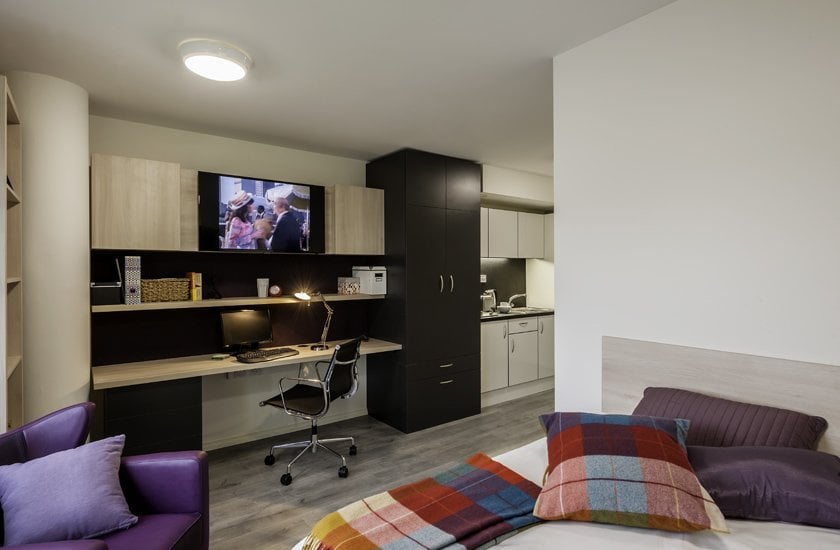 Desk TV shelves and kitchen student studio room at The Lyra in London Student Accommodation