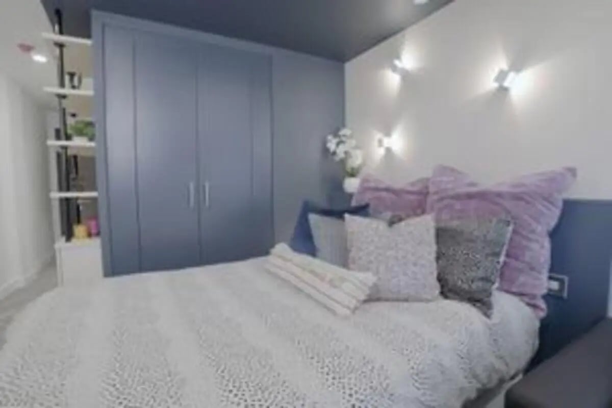 Bed with cushions and shelves Bedroom at The Orchard in Leicester Student Accommodation