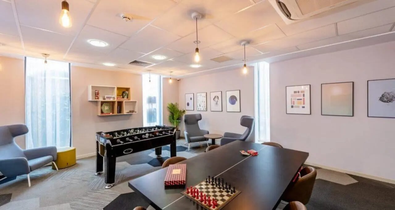 Foosball table chairs chessboard dining table common room at The Electra in Liverpool Student Accommodation