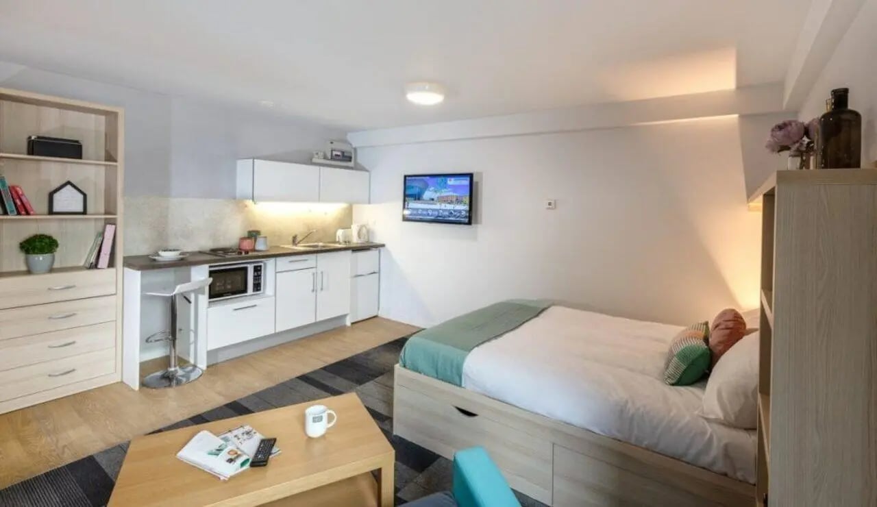 Bed kitchen bookshelf and table studio apartment at The Electra in Liverpool Student Accommodation