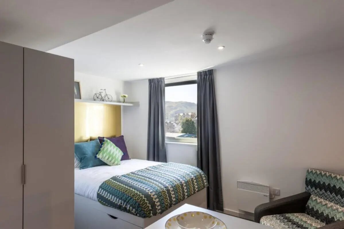 Bed wardrobe and patterned bedding bedroom at New Park in Edinburgh Student Accommodation