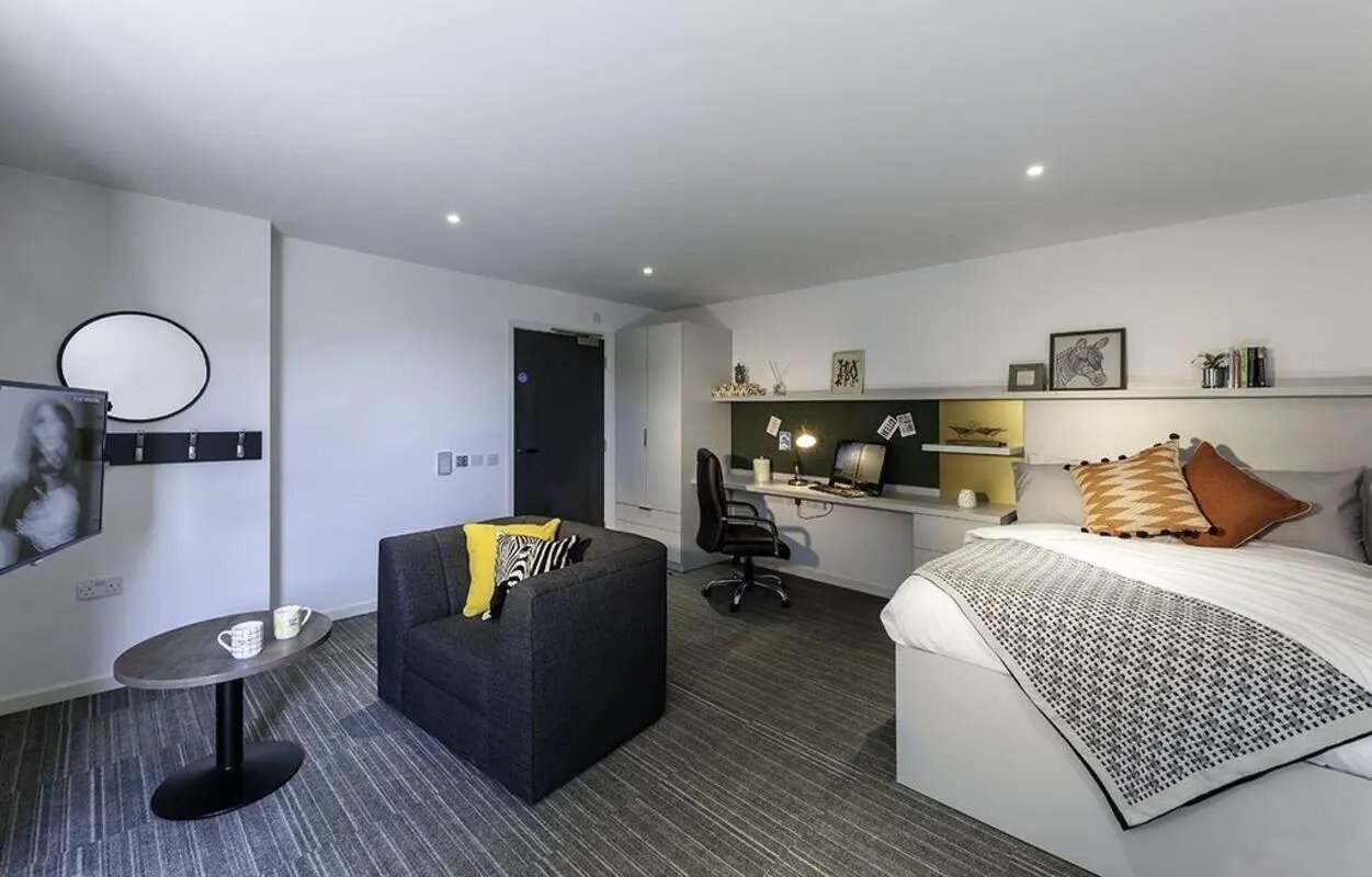 Bed desk chair sofa and TV bedroom at New Park in Edinburgh Student Accommodation