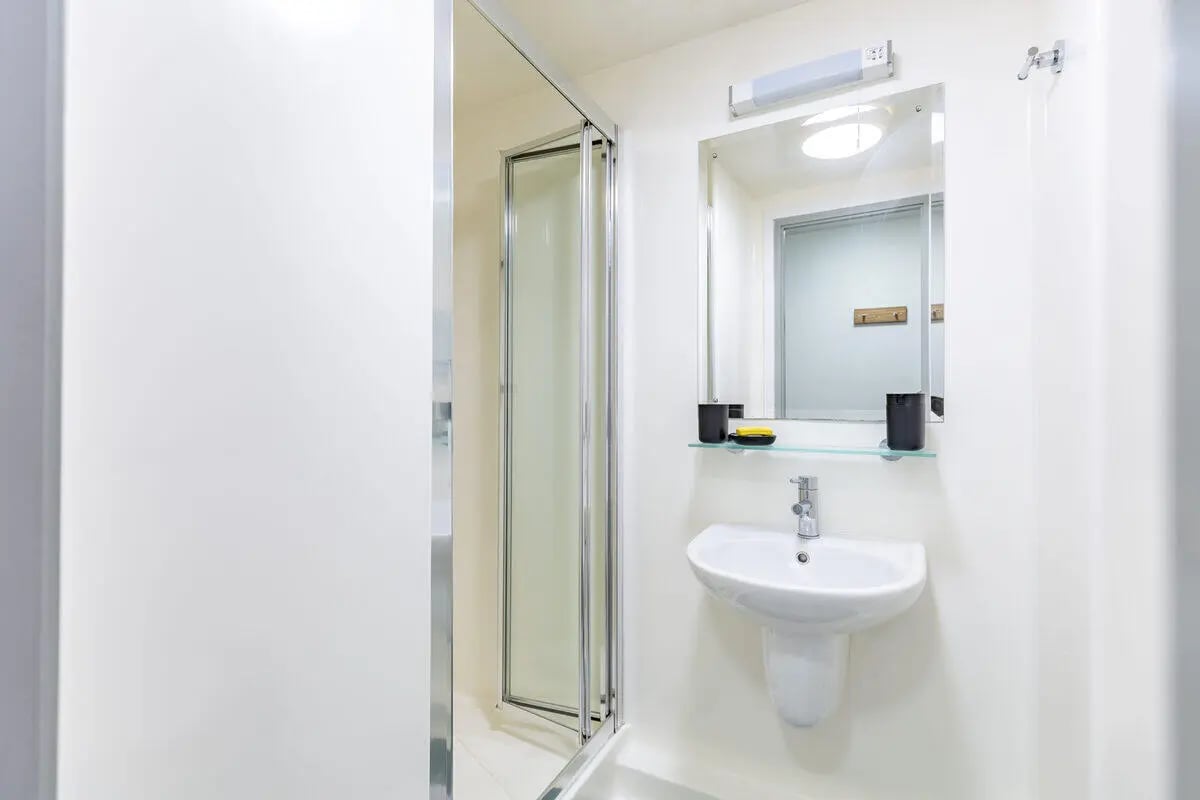 Shower sink mirror and toilet with white walls bathroom at Turner Court in Newcastle Upon Tyne Student Accommodation