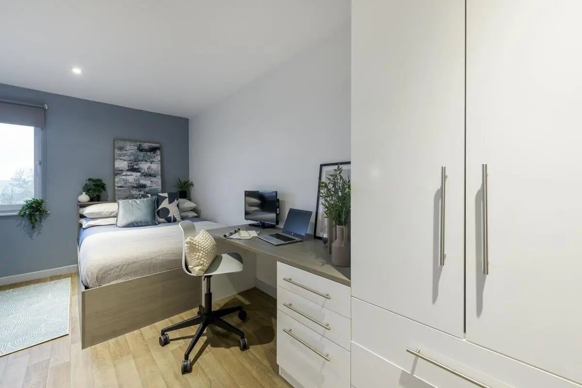 Bed desk chair monitor laptop artwork closet bedroom at The Bridge in Newcastle Upon Tyne Student Accommodation
