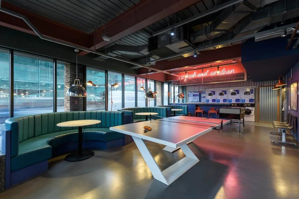 Ping pong table neon sign and washing machines lounge at The Bridge in Newcastle Upon Tyne Student Accommodation