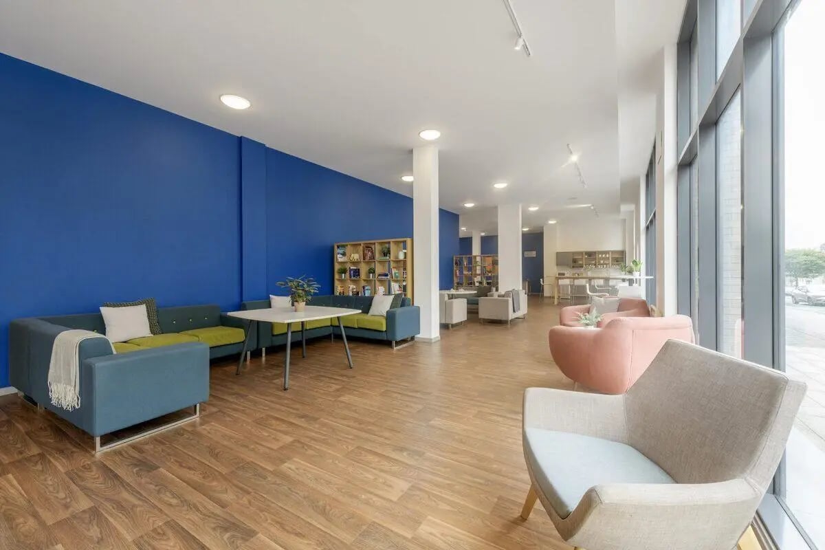 Blue wall sectional sofa white table living room at Bryson Court in Newcastle Upon Tyne Student Accommodation