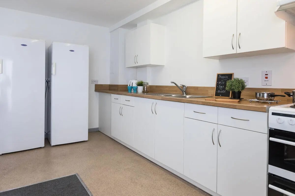 Two fridges sink stove white cabinets kitchen at Rosedale Court in Newcastle Upon Tyne Student Accommodation