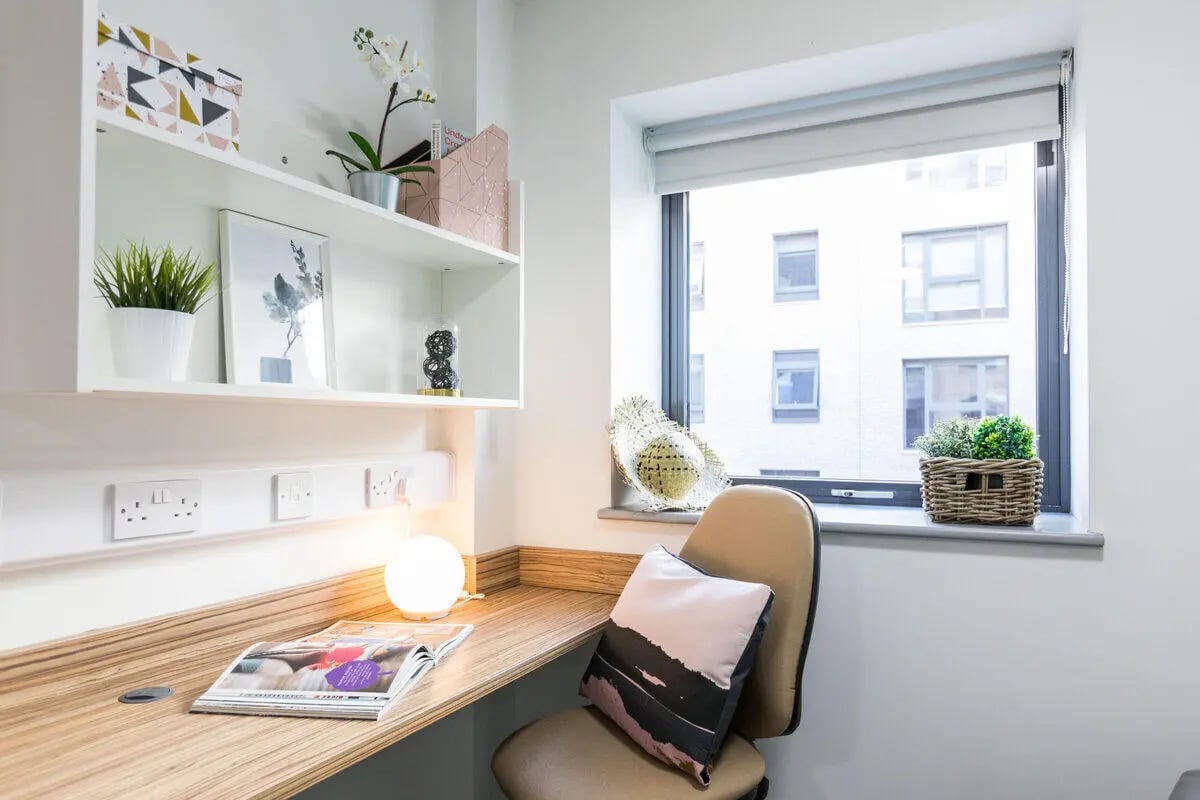 Desk with lamp chair pillow and plants Study area at Rosedale Court in Newcastle Upon Tyne Student Accommodation
