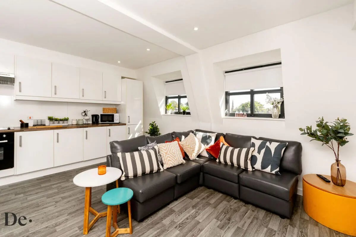 Dark sectional sofa with patterned pillows living room at Castle Hill in Cambridge Student Accommodation