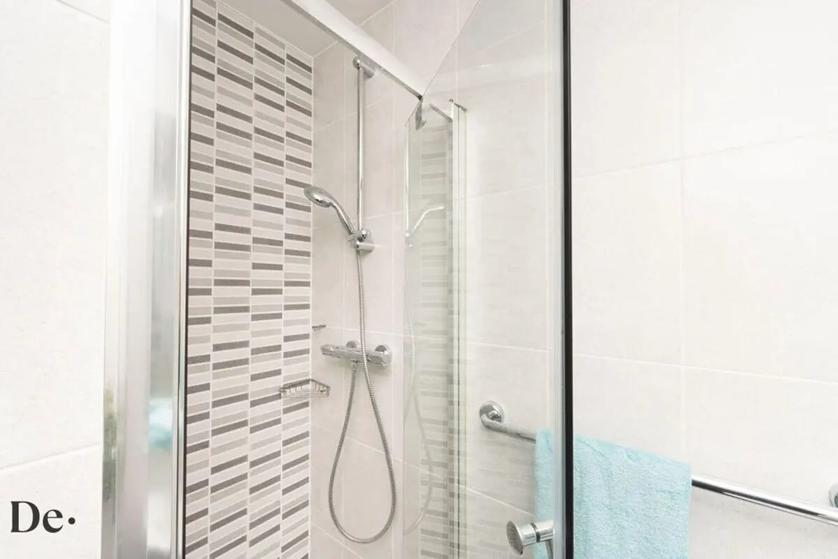 Shower faucet rack patterned tiles blue towel bathroom at Castle Hill in Cambridge Student Accommodation