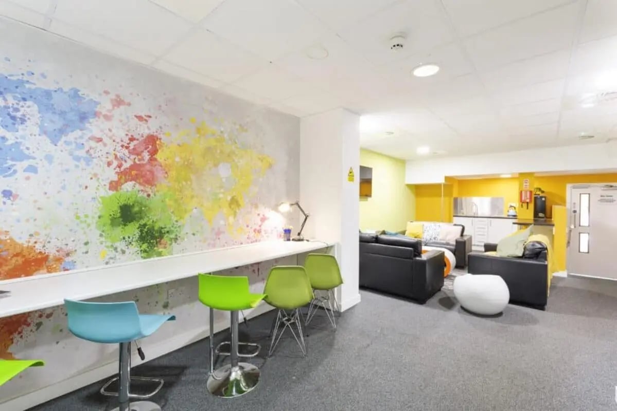 Colorful wall art desk with stools and sofas communal area at Tamarillo House in Bristol Student Accommodation