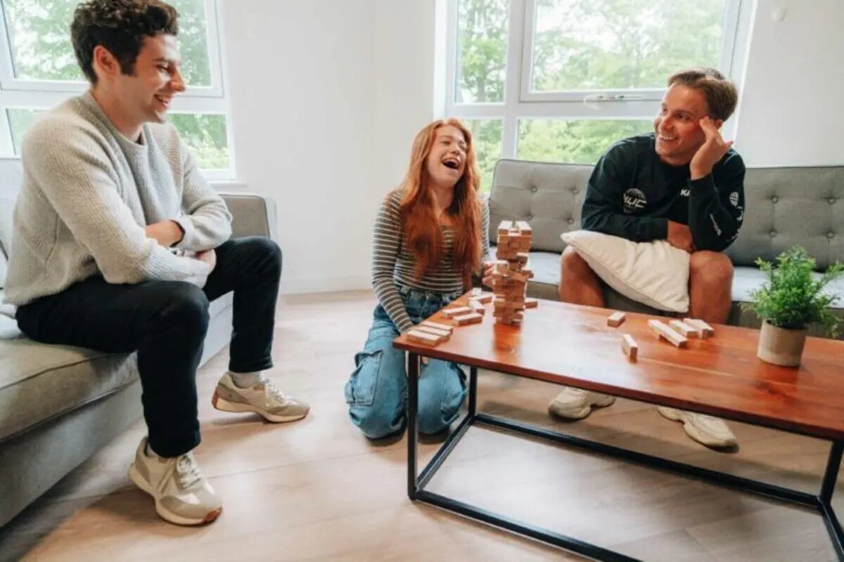 Friends playing Jenga on couch living room at Caledon Court in Aberdeen Student Accommodation