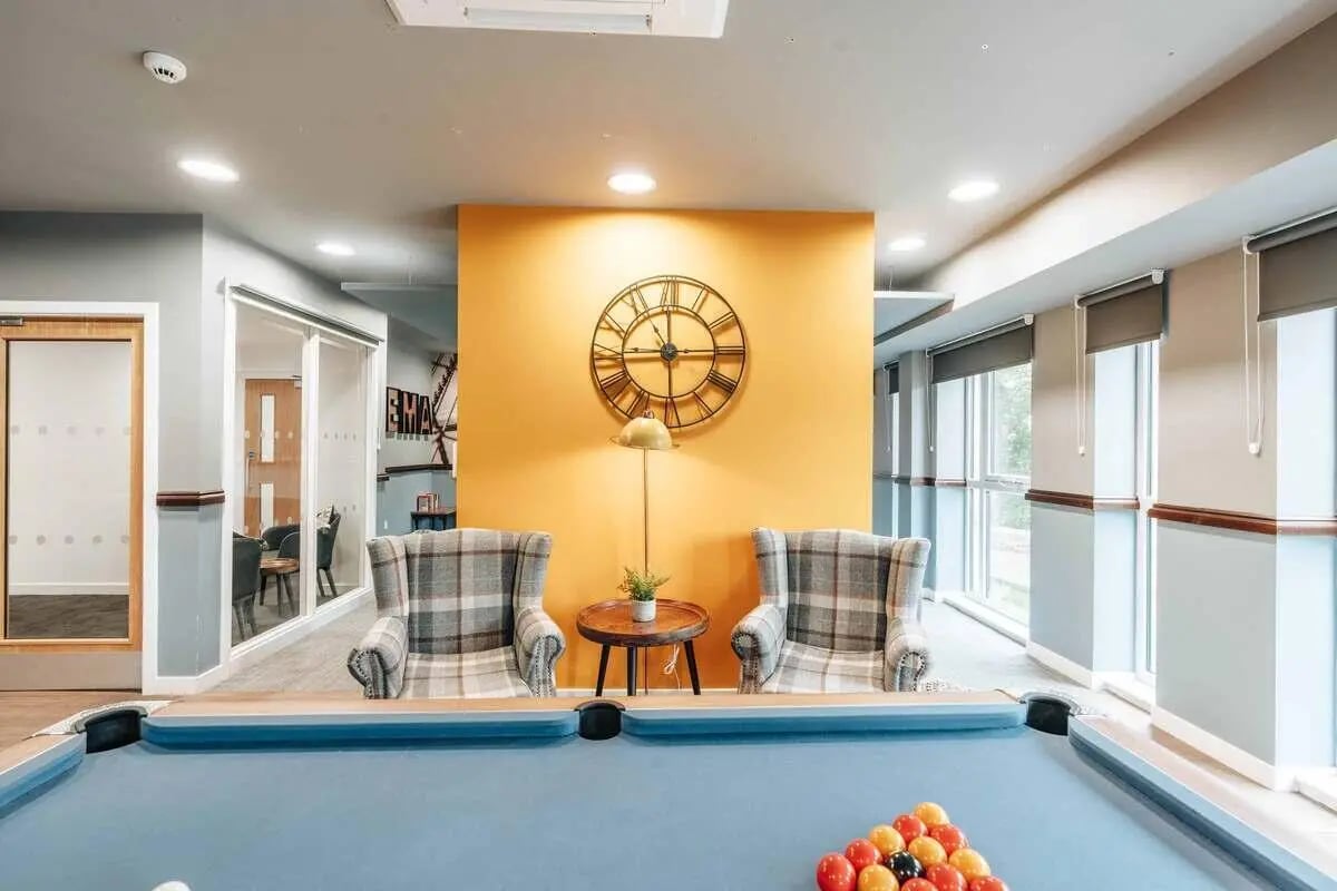 Pool table chairs clock and lamp living room at Caledon Court in Aberdeen Student Accommodation