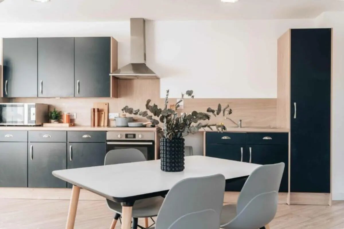Modern kitchen with grey cabinets table and chairs kitchen at Caledon Court in Aberdeen Student Accommodation