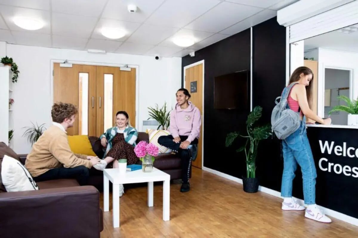 Students lounge on sofas at reception desk area at North Court in Cardiff Student Accommodation