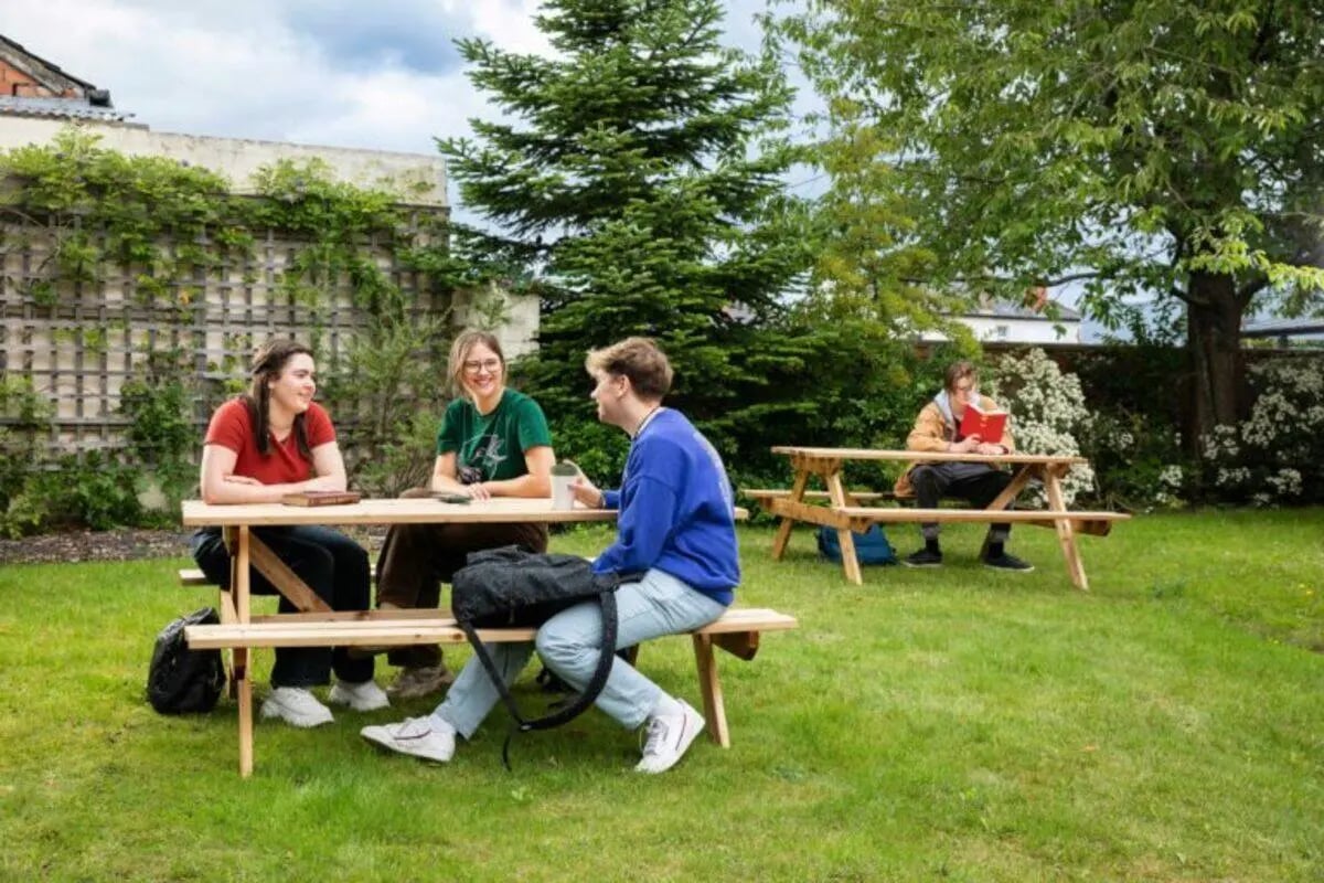 Students at picnic tables in a garden outdoor area at North Court in Cardiff Student Accommodation