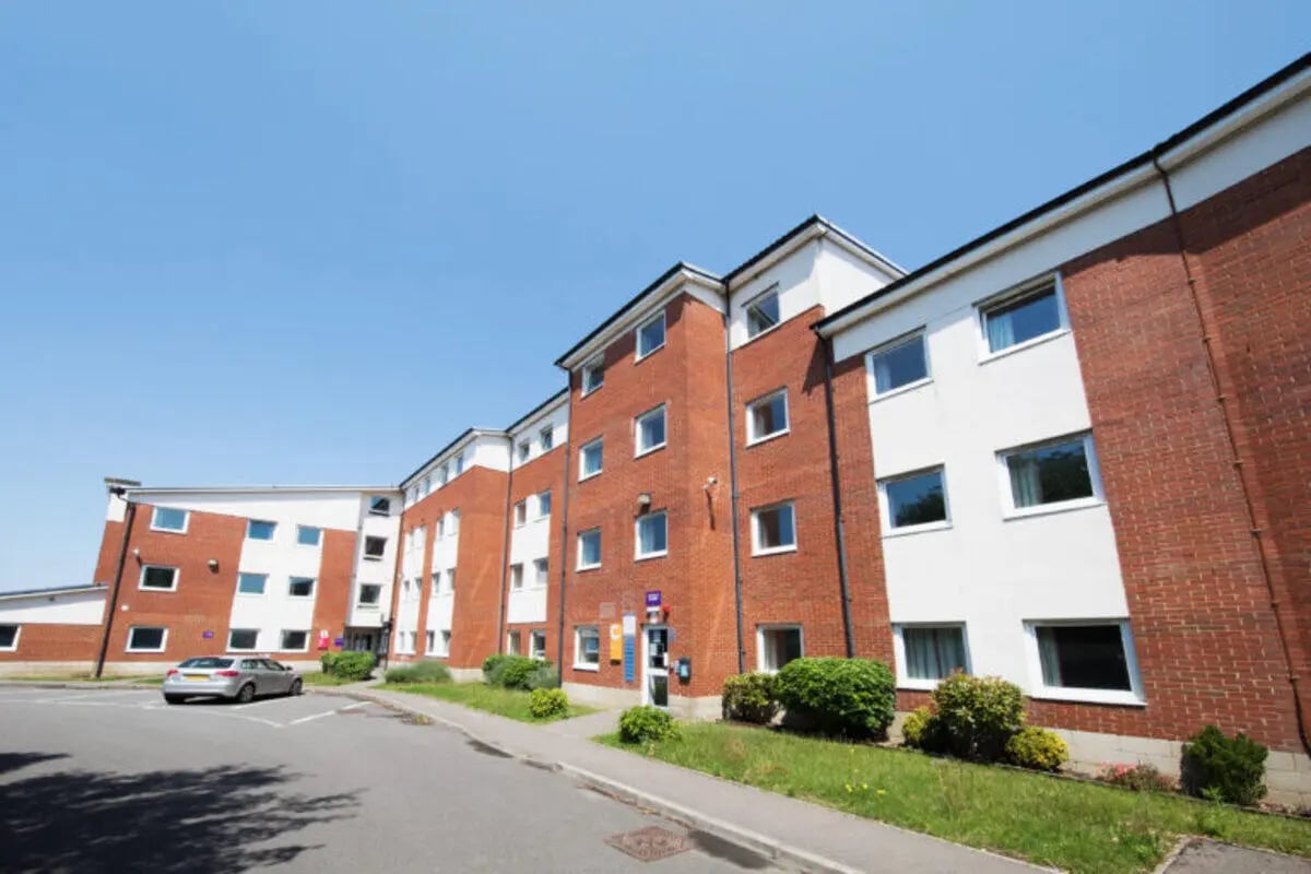 Brick and white building with parked car exterior at North Court in Cardiff Student Accommodation