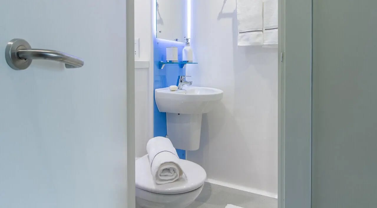 Toilet sink and towels in clean bathroom at The Toybox in Birmingham Student Accommodation