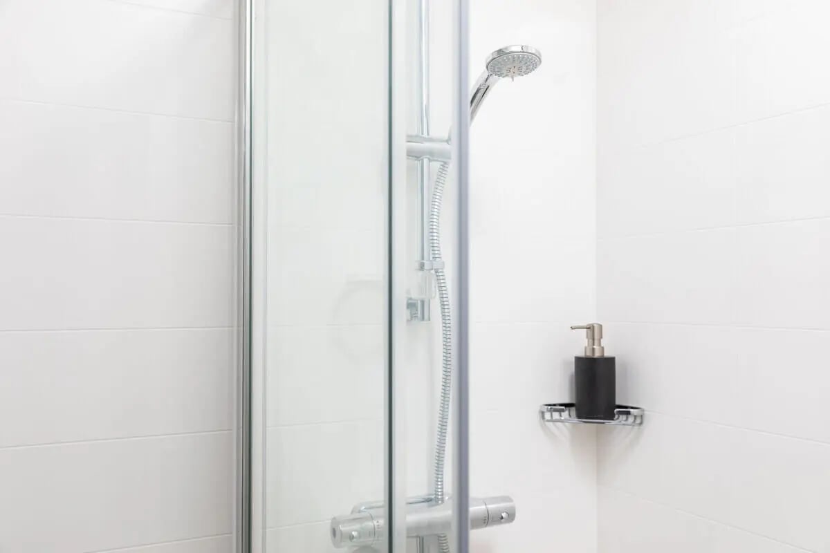 Shower head soap dispenser tiled walls bathroom at West Wing in Cardiff Student Accommodation