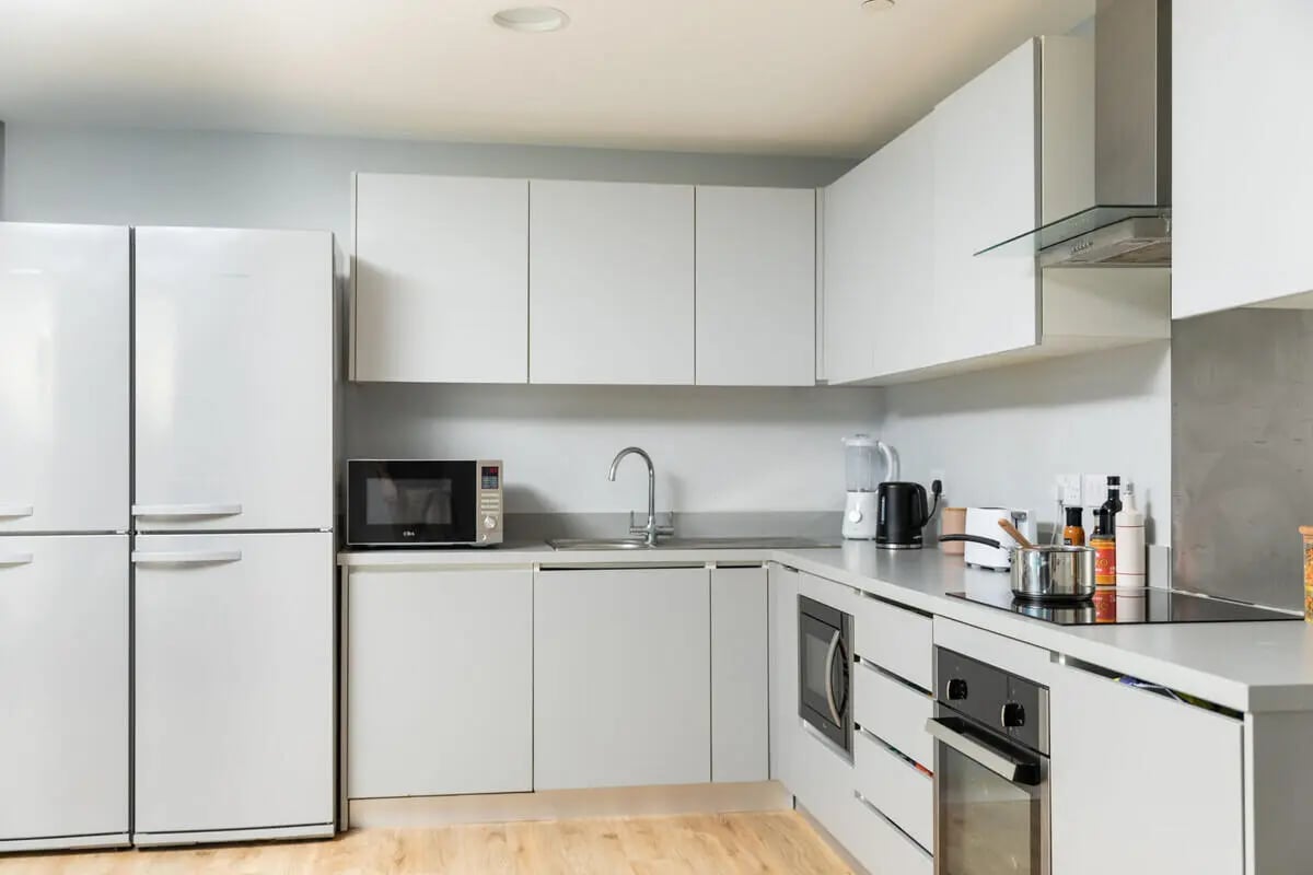 White fridge microwave sink cabinets and appliances kitchen at West Wing in Cardiff Student Accommodation