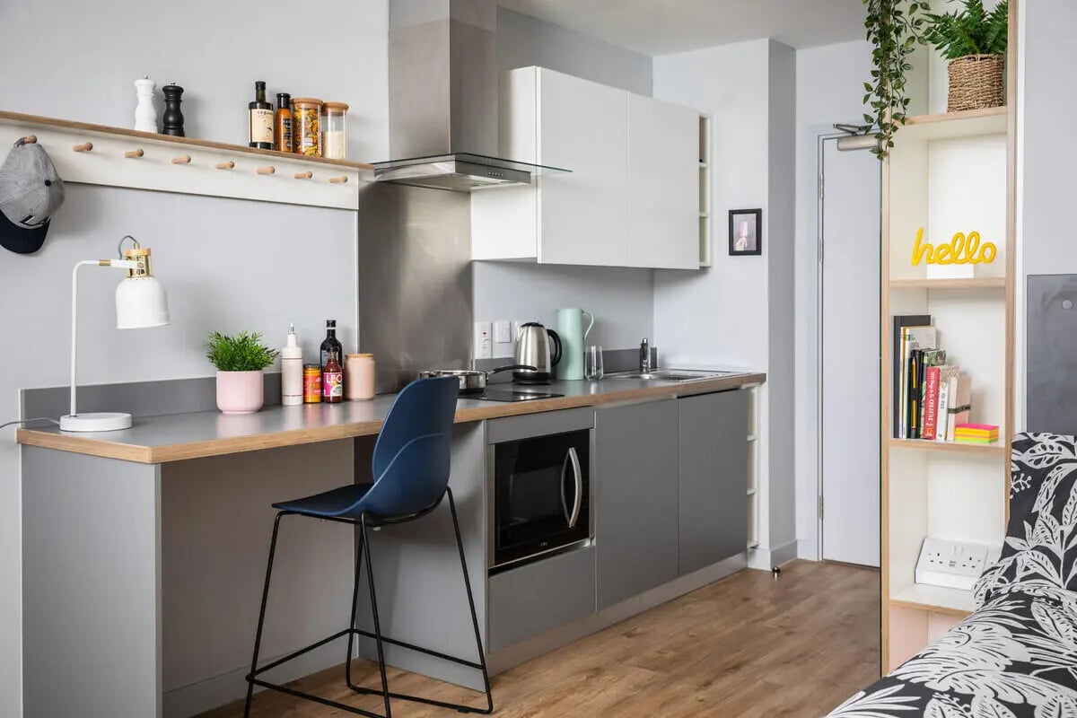 Compact kitchen with bar stool and shelves Kitchen at West Wing in Cardiff Student Accommodation