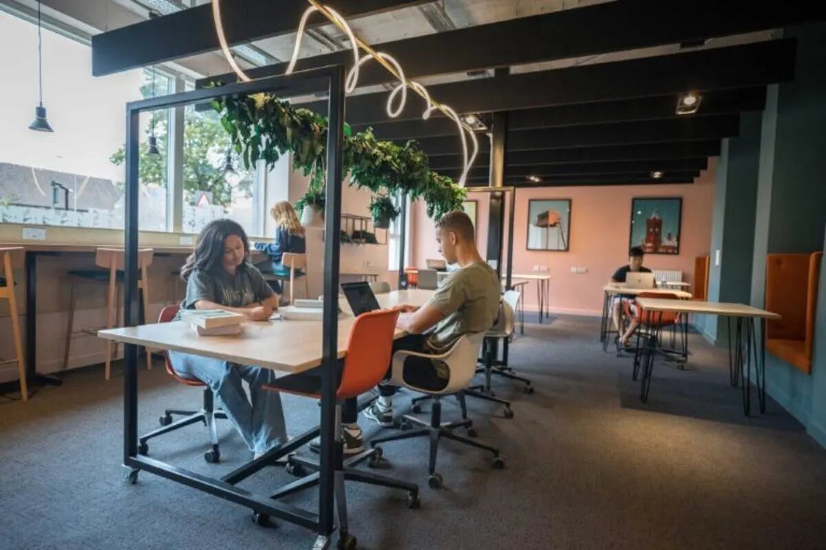People working at desks in a communal study space at West Wing in Cardiff Student Accommodation