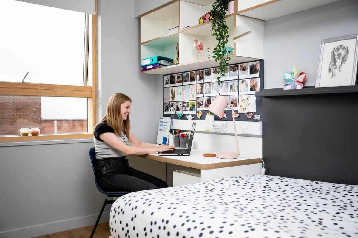 Student working at desk with laptop and photos Bedroom at The Depot in Bath Student Accommodation