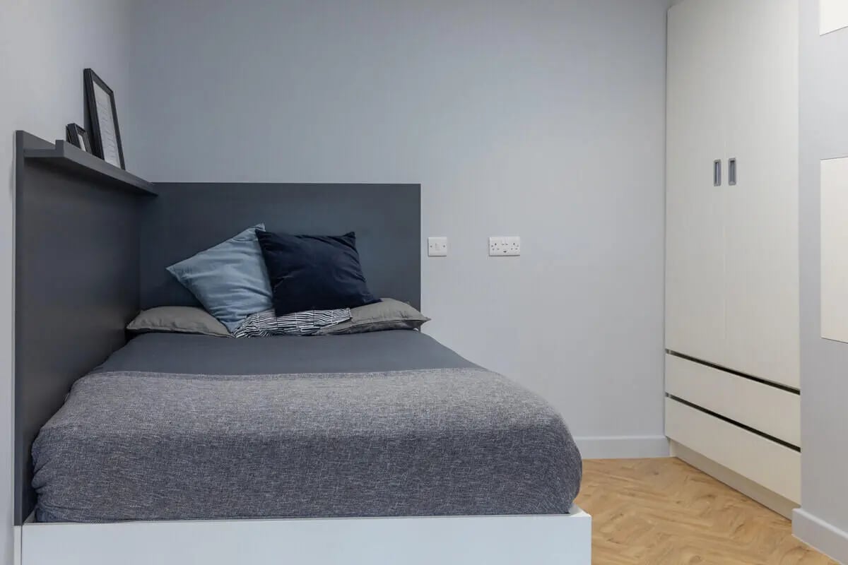 Bed with pillows shelf and wardrobe bedroom at The Depot in Bath Student Accommodation