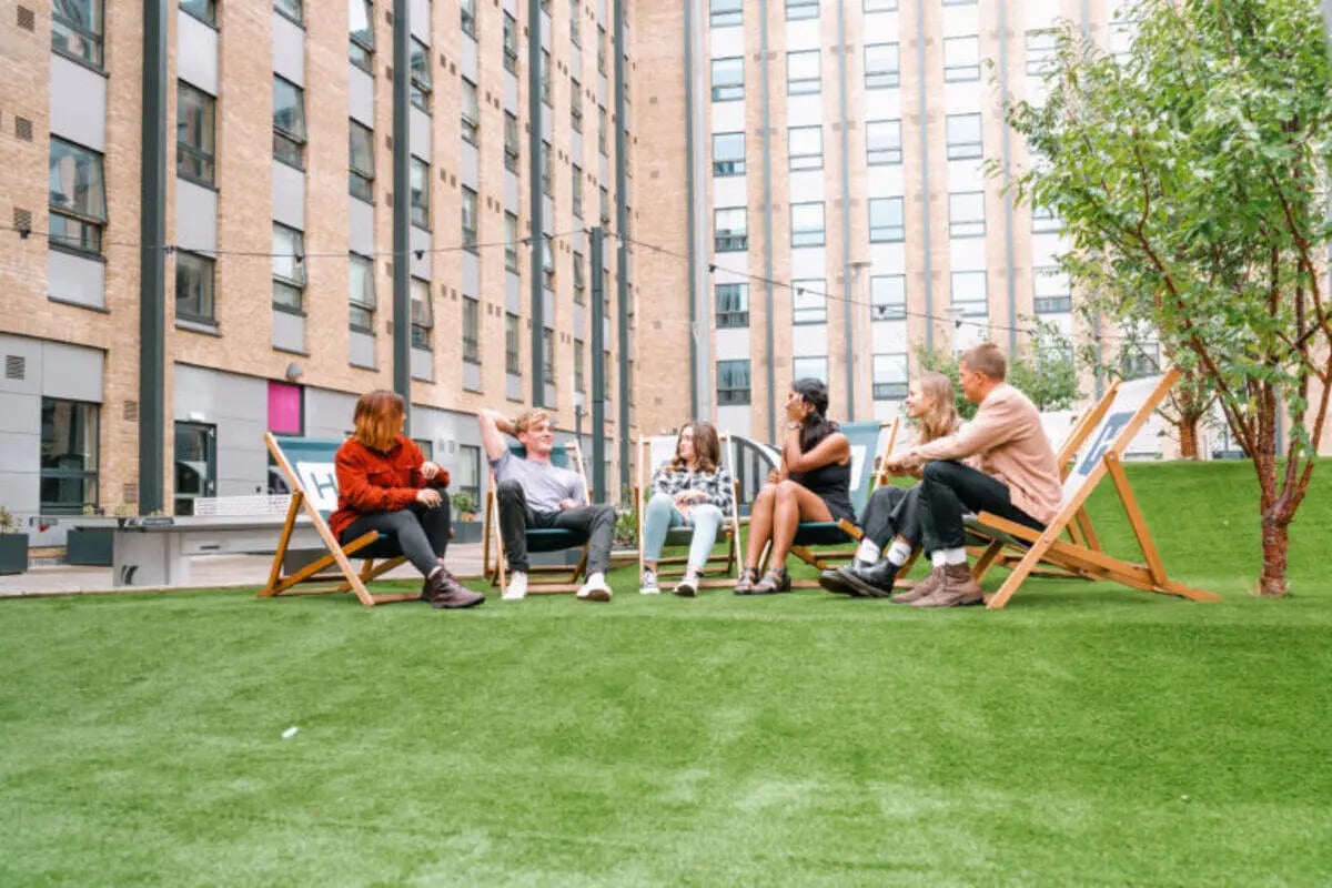 Students relaxing on lawn chairs exterior at The Depot in Bath Student Accommodation