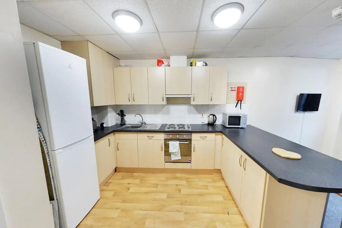 White fridge cabinets sink stove microwave kitchen at The Grange Leicester in Leicester Student Accommodation