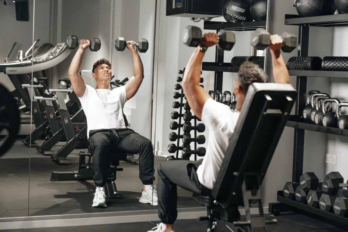 Man lifting weights on bench gymnasium Image Type at Alma Court in Canterbury Student Accommodation