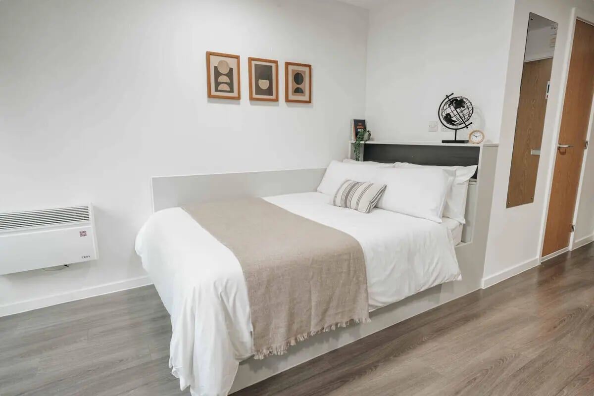 Bed with neutral blanket wall art and globe Bedroom at Alma Court in Canterbury Student Accommodation