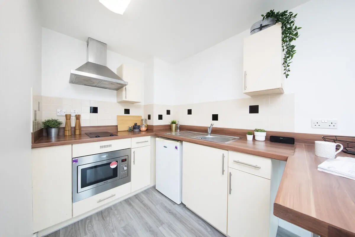 White cabinets microwave hob sink and fridge kitchen at Prospect Point in Liverpool Student Accommodation